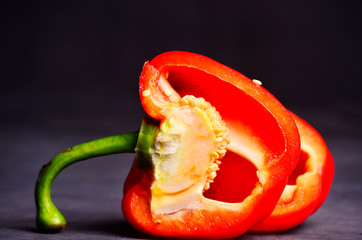 sweet red pepper and half cut isolated on black