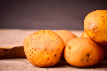 Fresh organic young potatoes on wooden black background