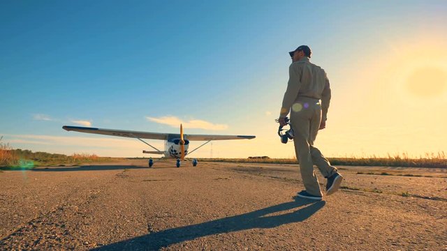 A pilot walking on an airfield to check an airplane, close up.