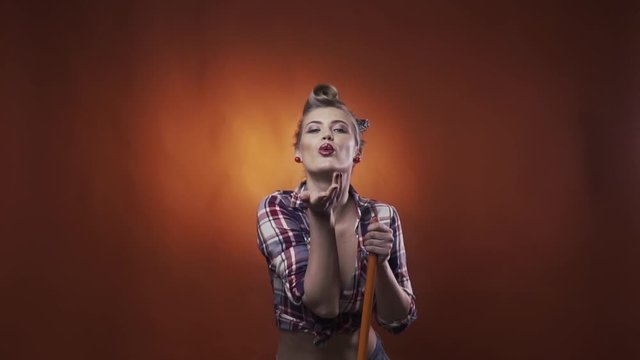 Sexy pin up woman with amazing makeup and hairstyle is blowing a kiss, slow motion