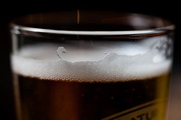 Poured beer in a glass with dark background. Alcohol beverage in the glass