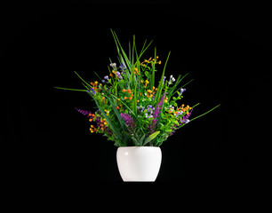 Beautiful artificial potted flowers on black background.