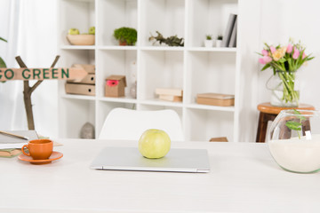 Fototapeta na wymiar workspace with apple on laptop near go green sign in modern office, environmental saving concept