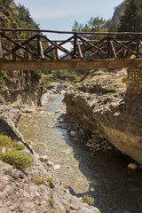 Wooden bridge over mountain river at rocky terrain of Samaria gorge, south west part of Crete island, Greece