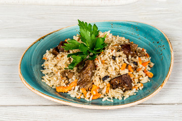 Pilau with pieces of meat decorated with greens