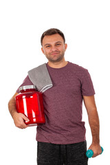 Young man holding a protein shake and a dumbbell