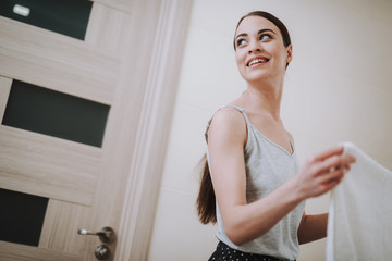 Joyful young woman standing in the bathroom