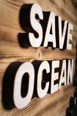 SAVE OCEAN words made with building blocks lying on wooden board.