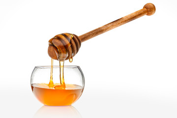 Honiglöffel mit einem runden Kunststoffschälchen als Freisteller 