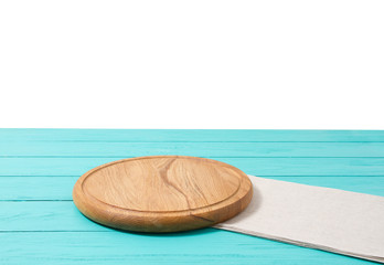 Round wood pizza cutting board and tablecloth on blue wooden table isolated on white background. Top view and copy space, Empty and template mockup with place for food.