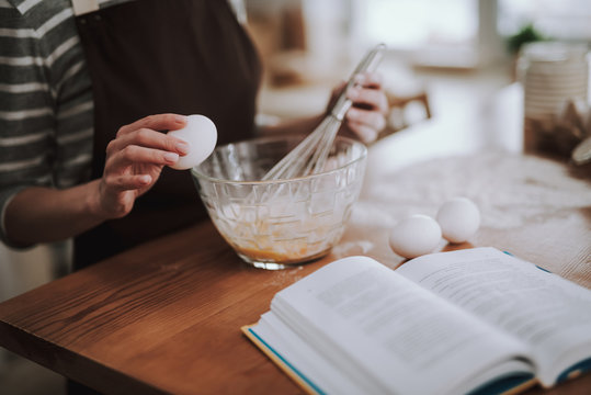 Woman is whisking eggs on kitchen at home