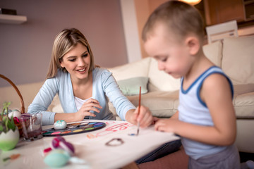 Obraz na płótnie Canvas Mother and little boy painting Easter eggs