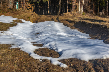 Fototapeta premium Snow in the spring on a forest road