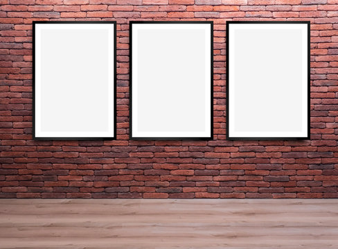 Set of three blank, vertical framed posters, on a brick wall, mock up