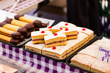 Pastries and cookies in the shop window with price tags. Delicious sweets on the sale. Food concept with selling pastries