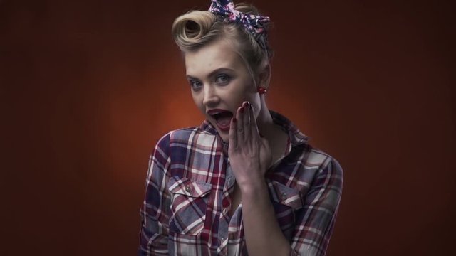 Blonde pin up girl is surprised and covering her open mouth with her hand