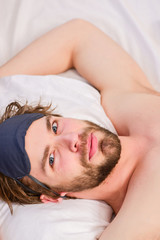 Fototapeta na wymiar Lazy man happy waking up in the bed rising hands in the morning with fresh feeling relaxed. Sleepy guy waking up early after hearing alarm clock signal on monday morning.