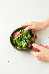 healthy green vegan salad in coconut bowl