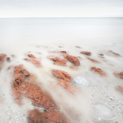 Long exposure artistic landscape, sea and red stones