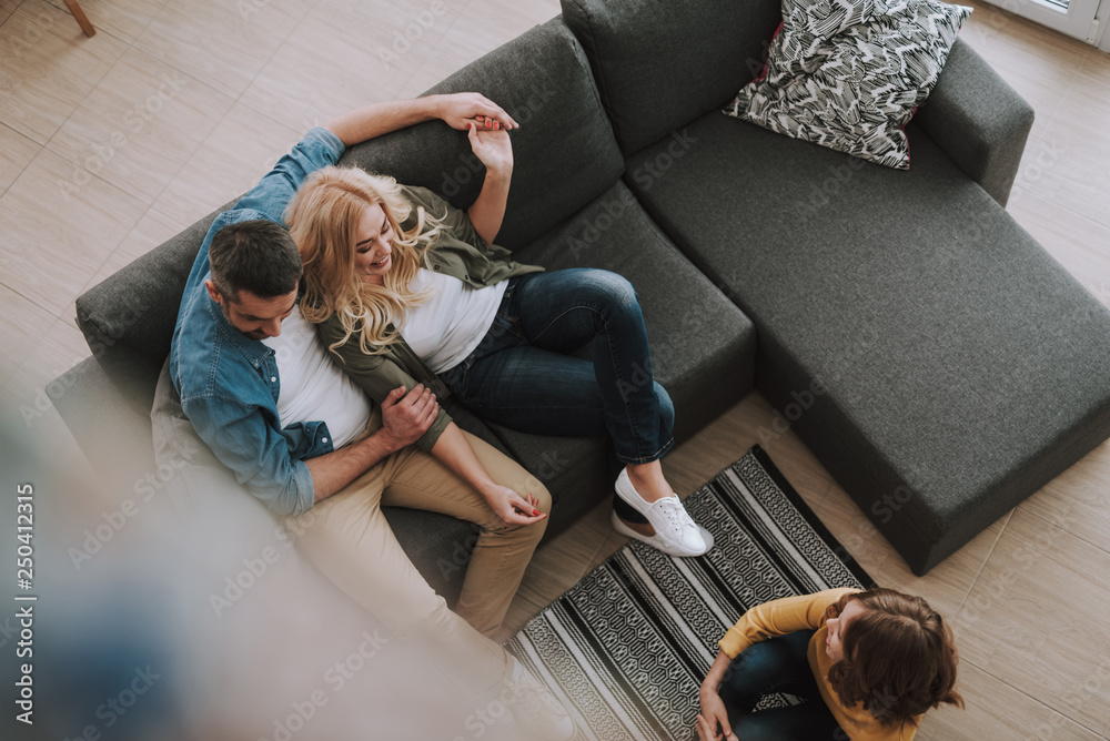 Wall mural Happy parents chatting with their cute daughter at home