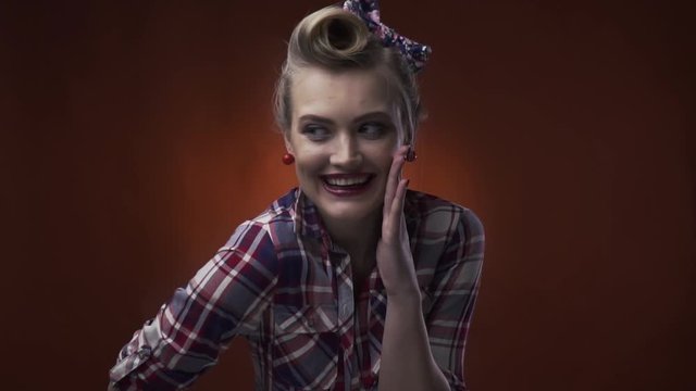 Happy laughing blonde pin up girl with 50s hairstyle and makeup