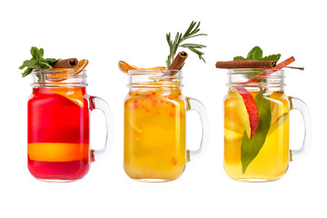 Three lemonade on a white background. Refreshments from fruits and berries in glass decanters.
