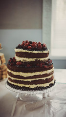 naked cake with cream, garnished with berries.