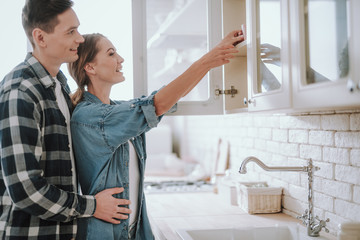 Obraz premium Woman putting cup on the shelf and man hugging her