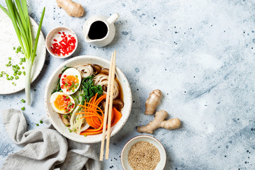 Ramen traditional japanese noodle soup with eggs, pak choi cabbage, meat broth, carrot, mushrooms...