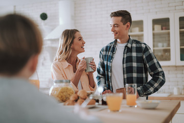 Happy couple talking in the kitchen and smiling