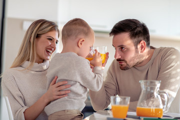 Family with child having fresh fruit juice at home