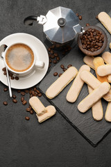 Italian Savoiardi ladyfingers Biscuits and cup of coffee on concrete backgound