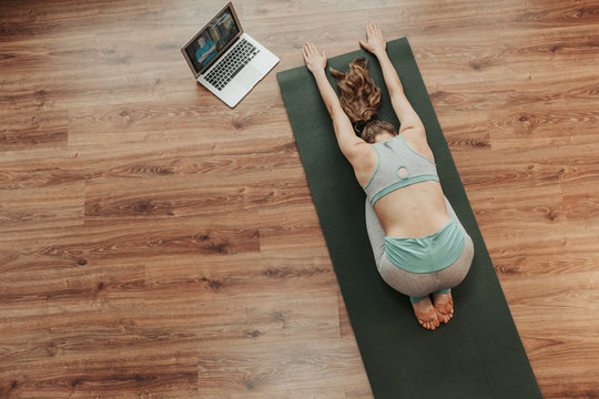 Young Lady Doing Child's Yoga Pose At Home