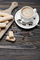 Italian Savoiardi ladyfingers Biscuits and cup of coffee on wooden backgound