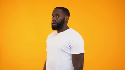 Black male in white t-shirt calling people to action, activist looking at camera - Powered by Adobe
