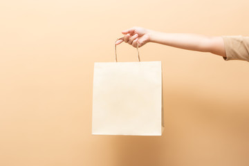Fototapeta Hand holding a paper bag isolated on background obraz