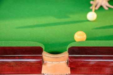 Man's hand playing snooker in bar with snooker ball