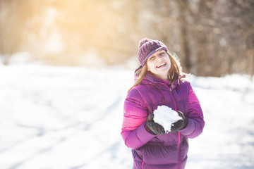Cheerful girl with snow in her hands