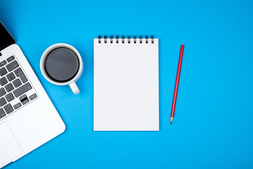 Minimal workplace with laptop and blank notepad