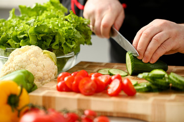 Cook holds knife in hand and cuts on