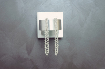 Fototapeta na wymiar earrings on modern lamp on gray wall
