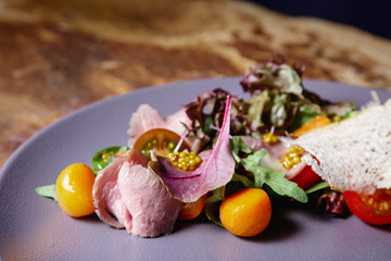 Appetizing tasty healthy vitamin salad with meat, fresh vegetables, tomatoes, carrots and French...