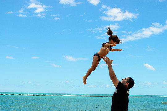 pai e filha se divertindo na praia
