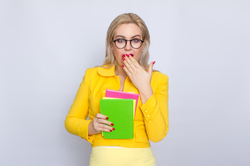 Woman in yellow suit holding books in her hands