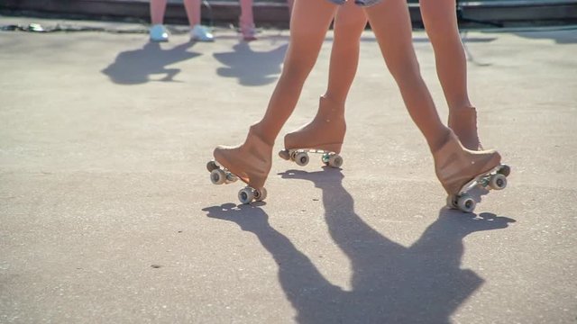 Two girls are performing a piece of choreography on roller-skates together.