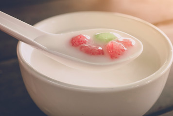 Thai dessert ,Waterchestnut in coconut milk ,serving on wood table with soft light morning background