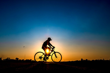Fototapeta na wymiar Silhouette of cyclist in sunset background.