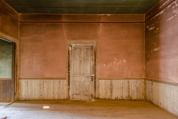 Dirty pink wall and wainscoting in an abandoned farm house