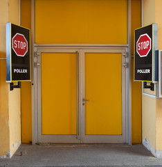 Stop signboards next to the yellow door