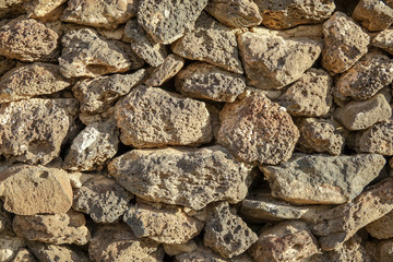 Stone wall made of volcanic rocks, background texture.